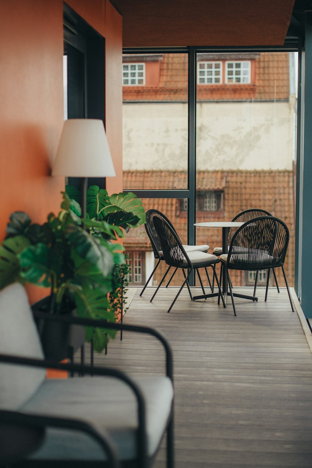 Small apartment balcony with chairs, a table and potted plants