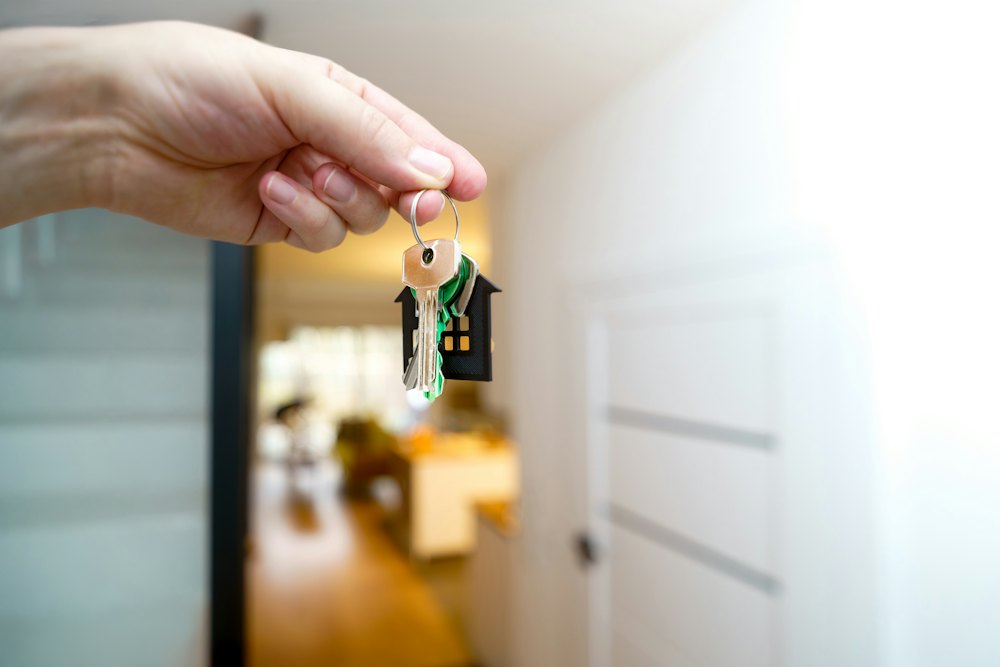 A house key being handed over at an apartment door