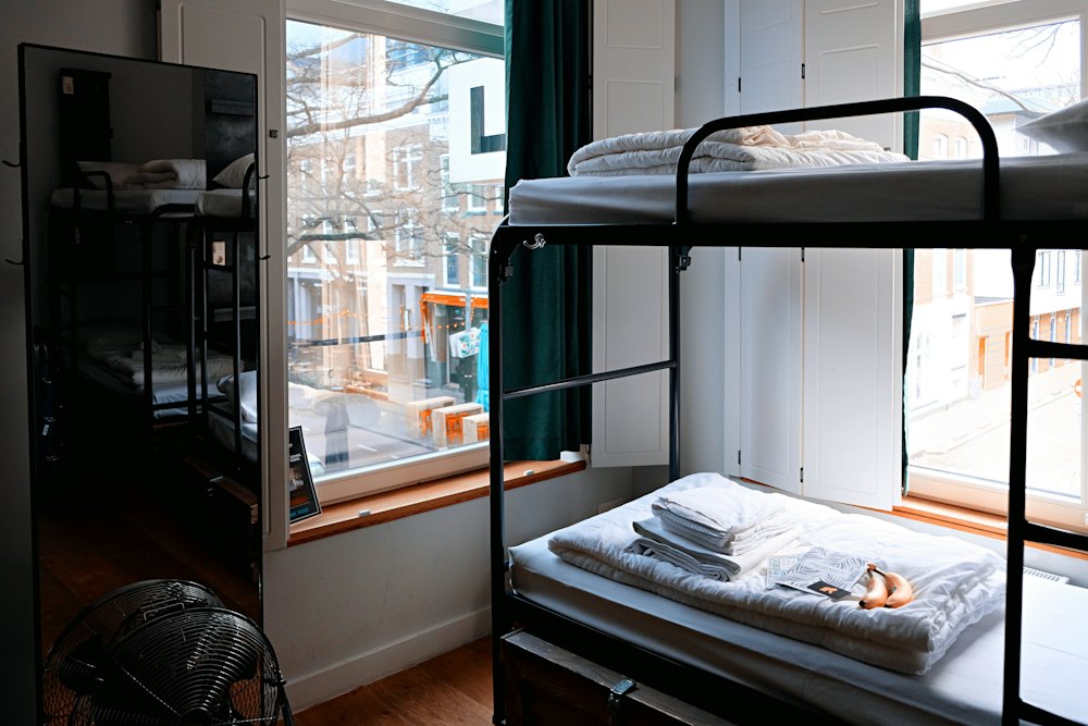 Hostel room with bunk beds beside a window